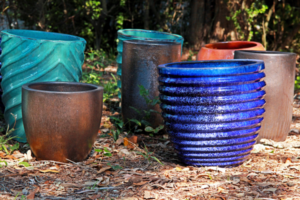 A variety of colorful ceramic planters sitting on the ground